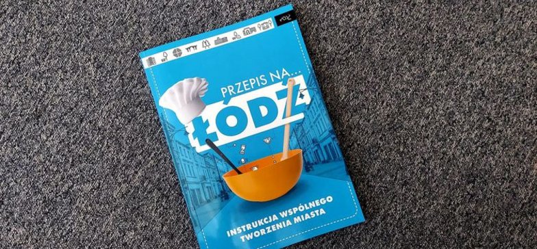 Błękitna książka z biało-niebieskimi napisami: Przepis na Łódź. Grafika okładkowa nawiązuje do kulinariów.